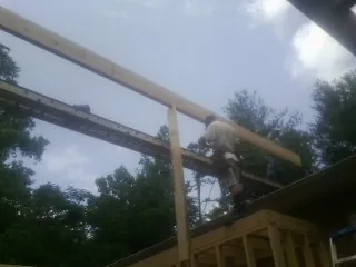 Carpenter setting a ridge beam over a new addition frame — Ice Dam Removal by Roofing Brothers in Labadie