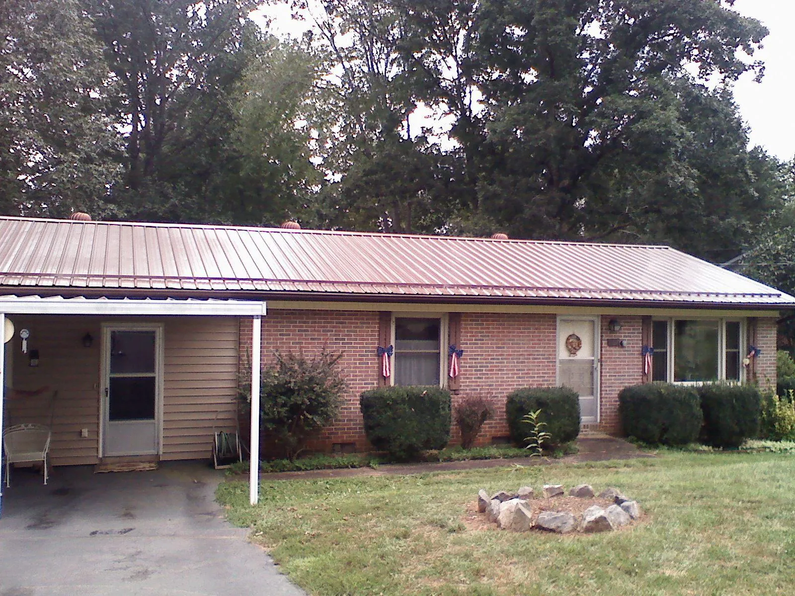 Bronze metal roof and carport on a brick ranch home — Roof Repair work by our crew in Labadie
