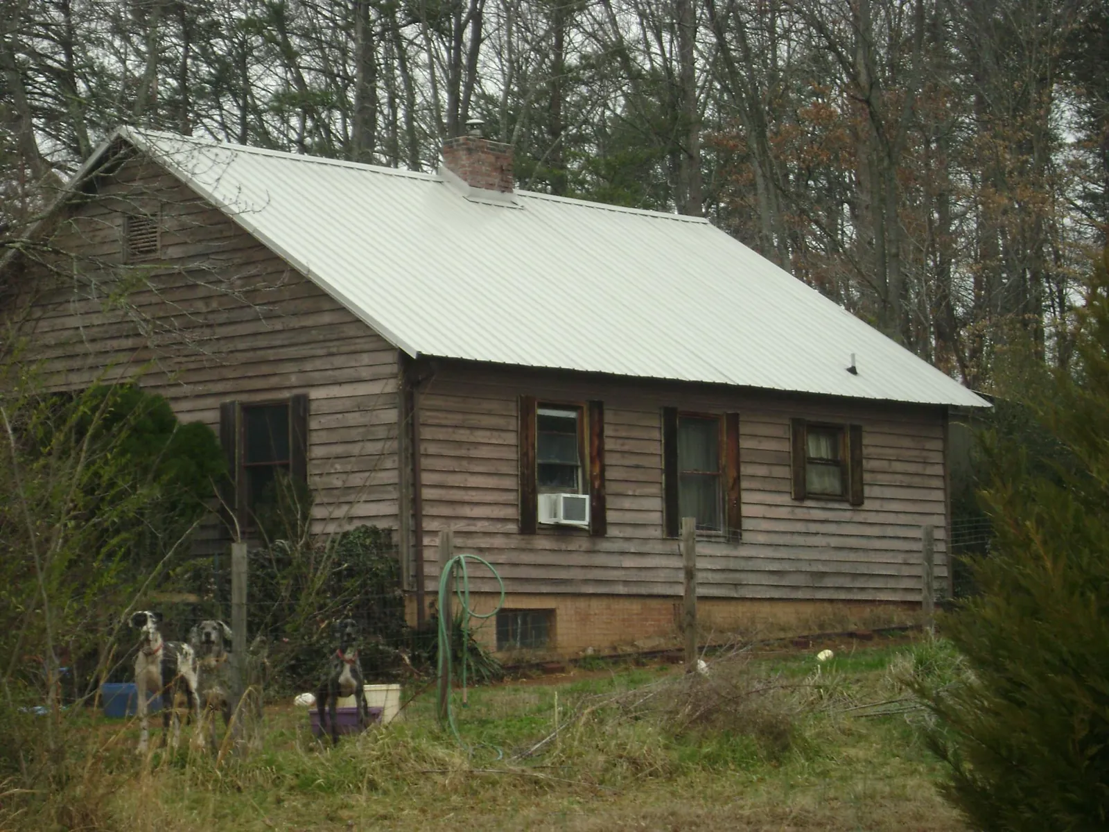 White metal roof on an old wood sided farmhouse, from a Metal Roof Installation job in Labadie